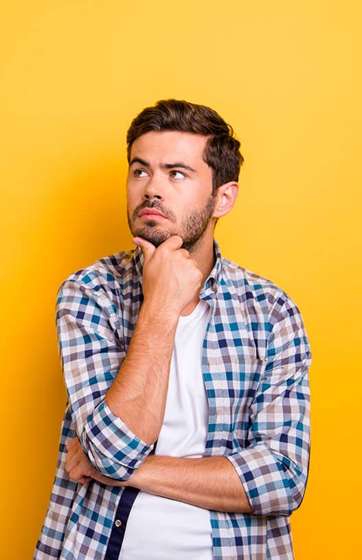 Guy in front of orange background in thinking position