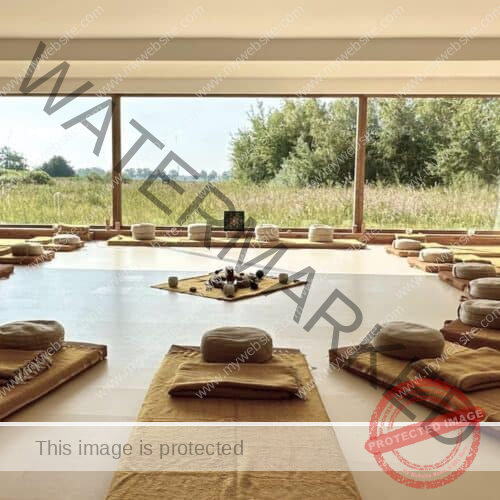 Interior of the ceremony room at the retreat center. Through the large glass wall you have a view of the estate. Inside, the atmosphere is warm, and there are 12 mattresses with meditation cushions on them in a circle.