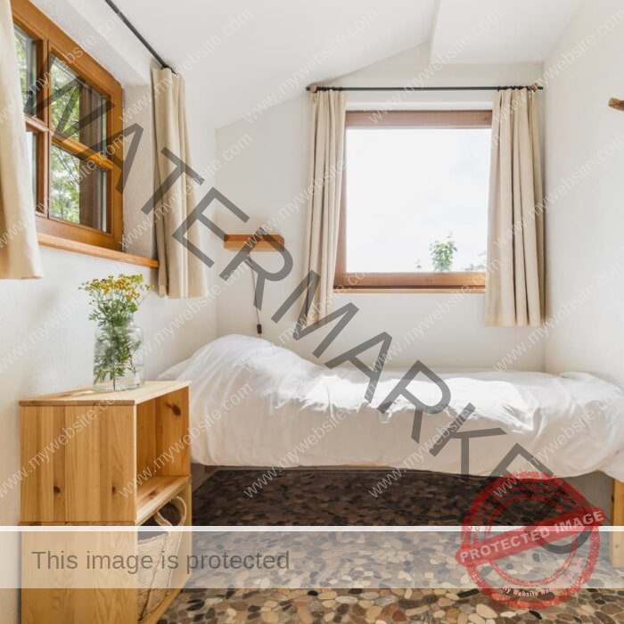 One of the double rooms. It is a bright room with white walls. All the furniture, the door and the bedside lamp are made of solid wood. The room streets a serene peace.