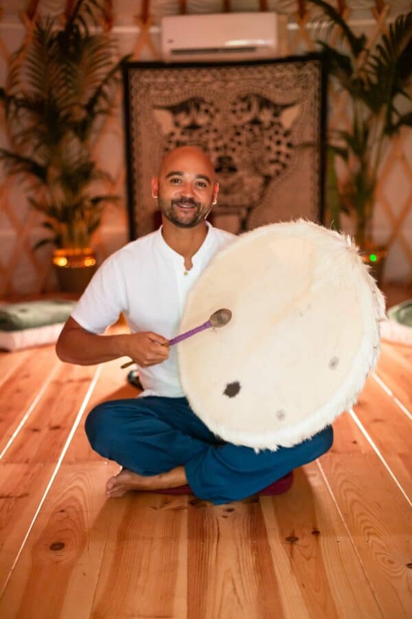 ceremony leader drum ceremony leader playing a shamanic drum inside a warm lighted ceremony room