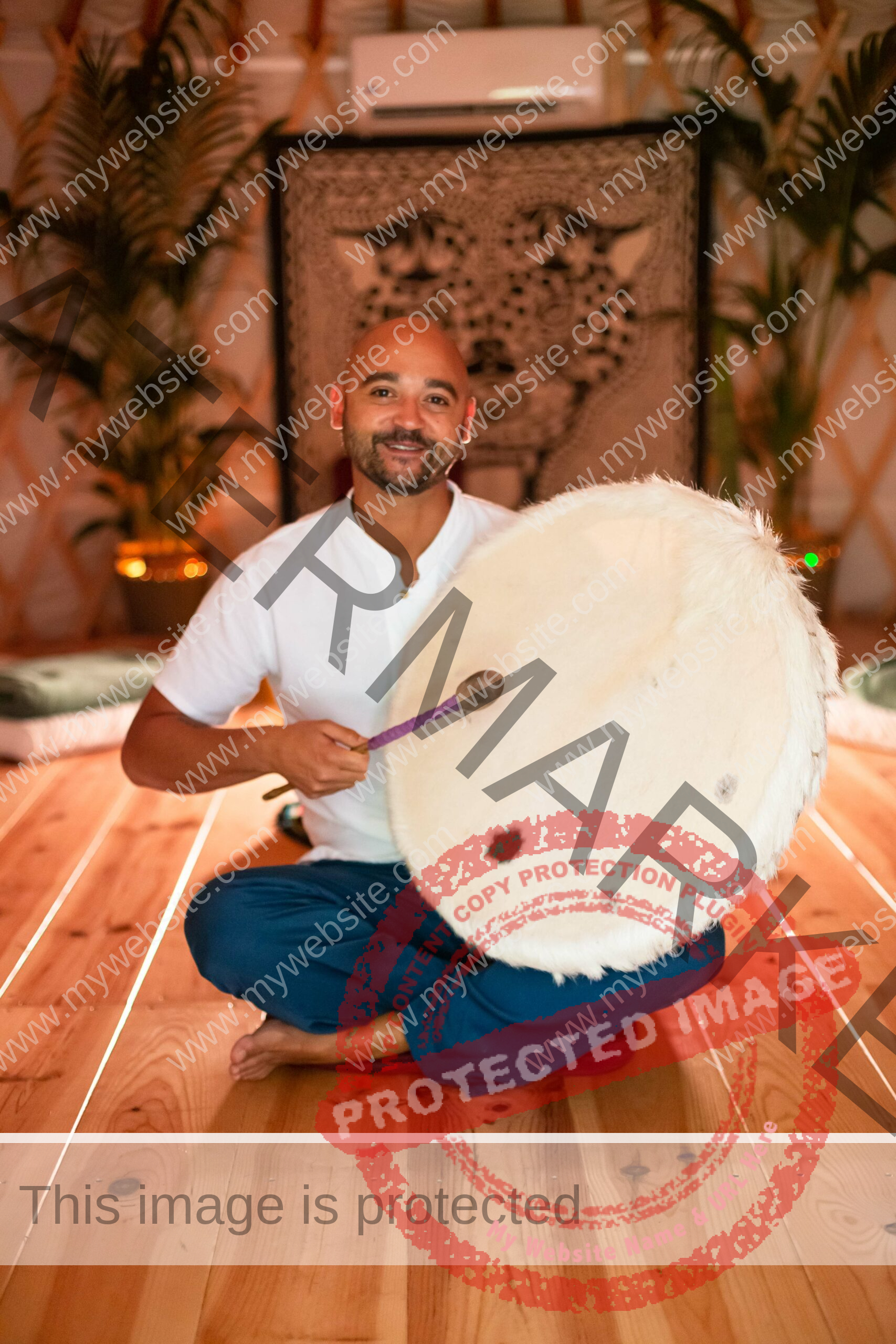 ceremony leader playing a shamanic drum inside a warm lighted ceremony room