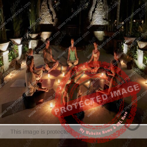 8 people sitting in a circle while in a meditation position, candles between them in a dark room