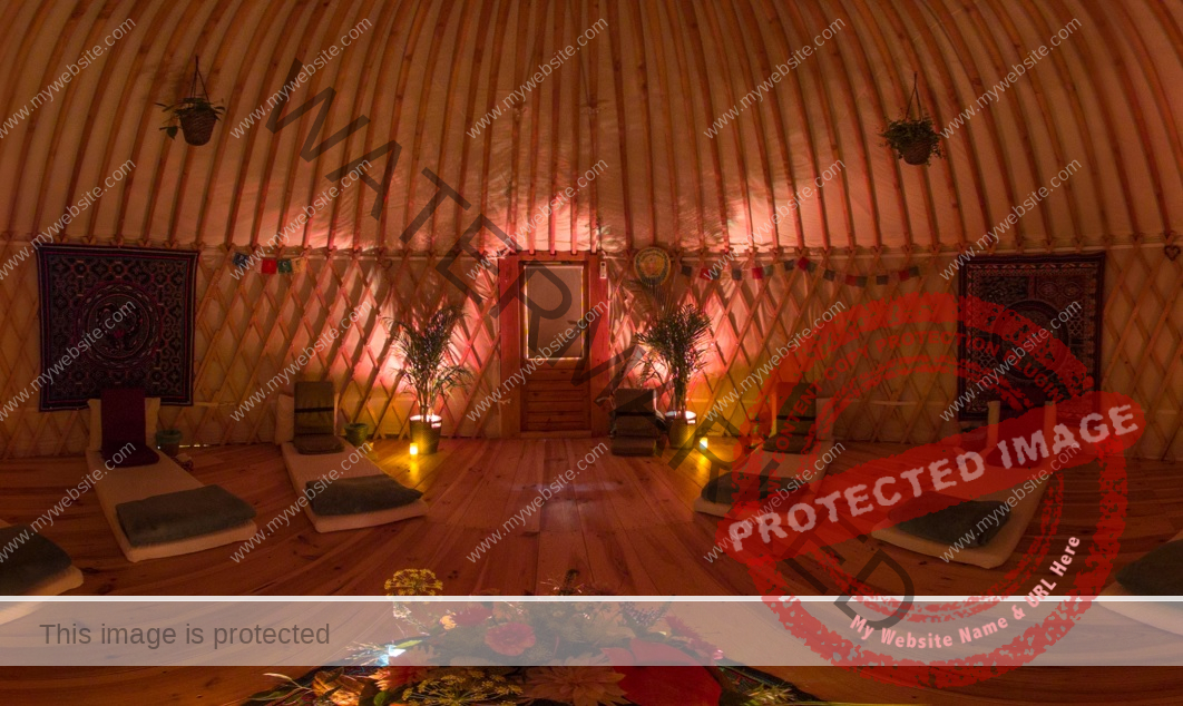 Retreat ceremony room with warm light, mattresses and meditation seats