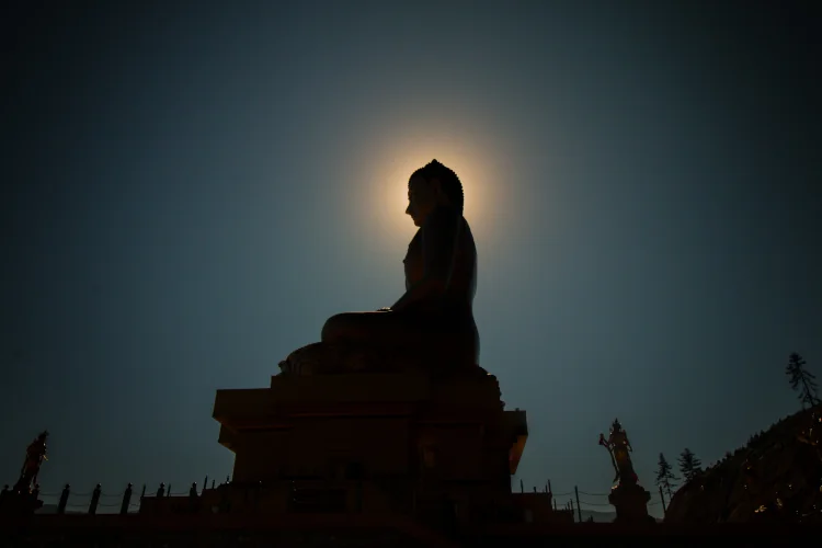 Buddha statue, moon shining behind the buddha head