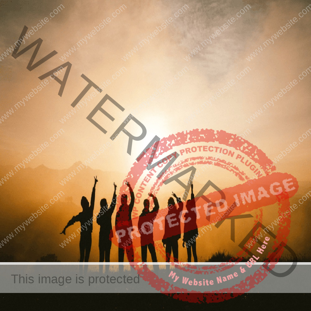 Group of people standing on mountain while sun rises, holding their hands up