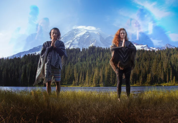Woman and Man standing and praying in nature, mountain in the background