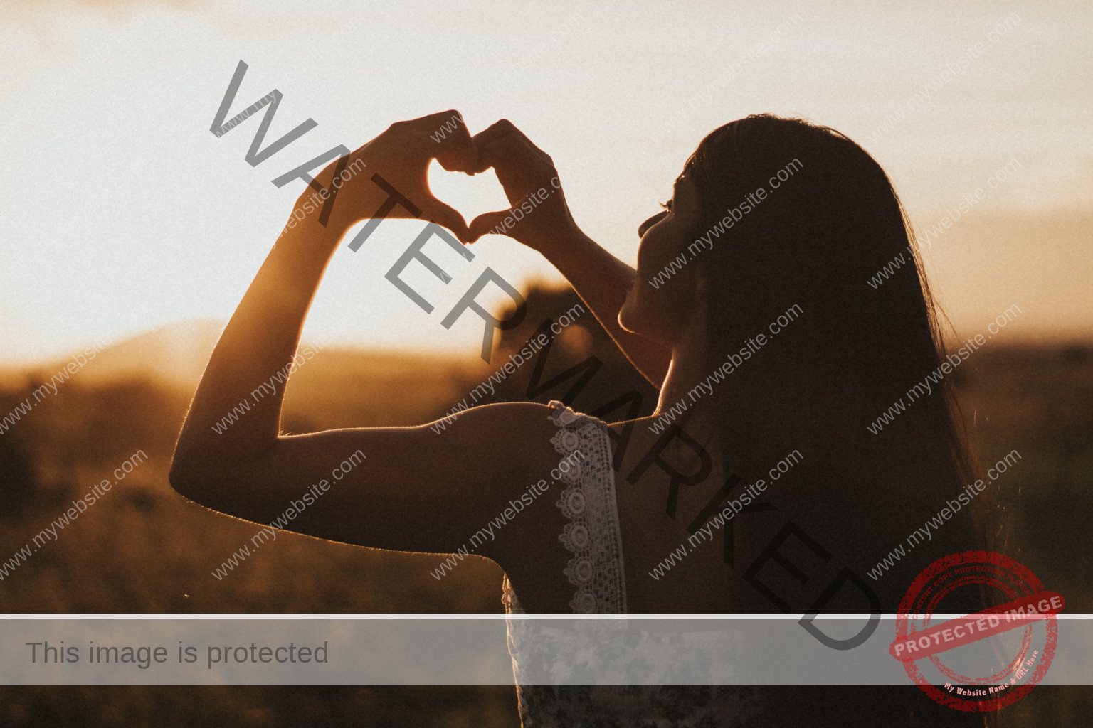 Young woman holding heart shaped hands into sun rise