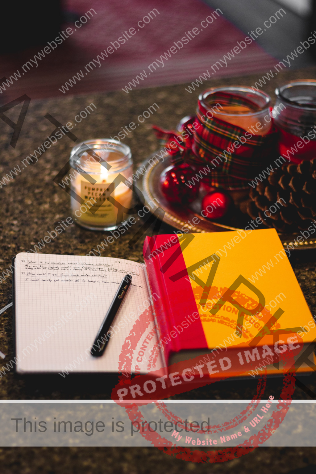 opened journal with notes, lightened candle and a book on a dark table