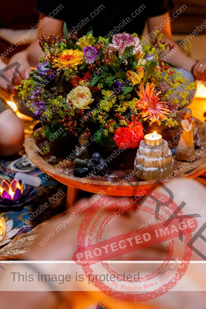 Blooming Flowers on wooden table, a group of people sitting around it and holding hands