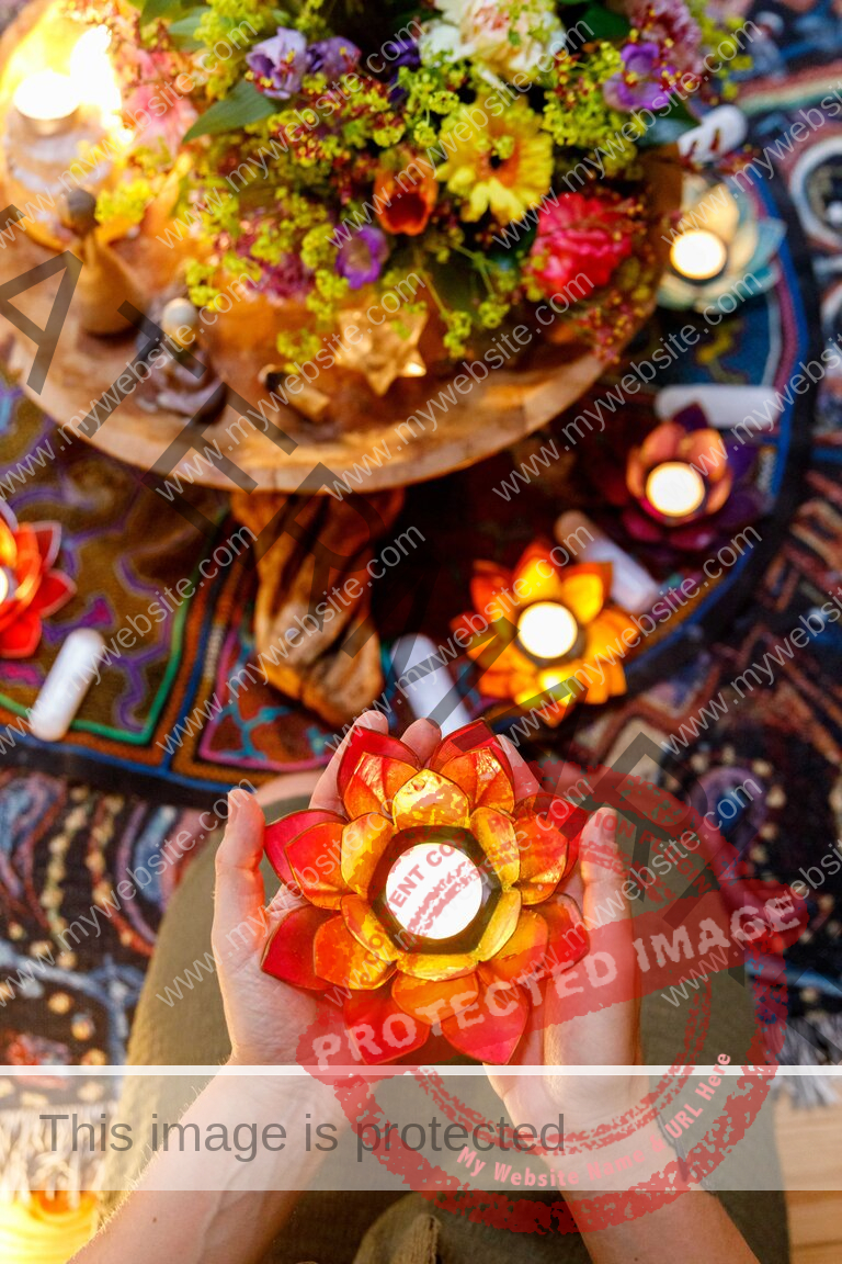 Two hands are holding a lotus flower candle