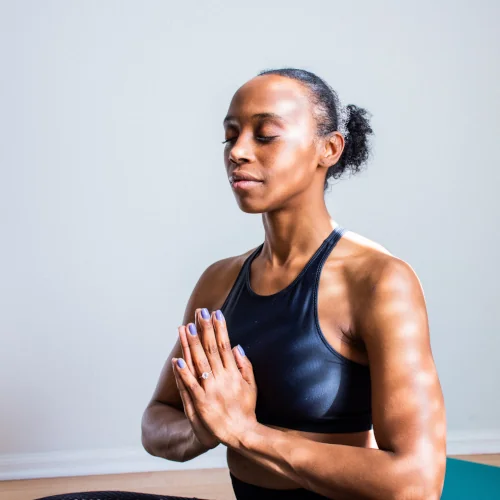 Woman meditating with praying hands in front of her chest