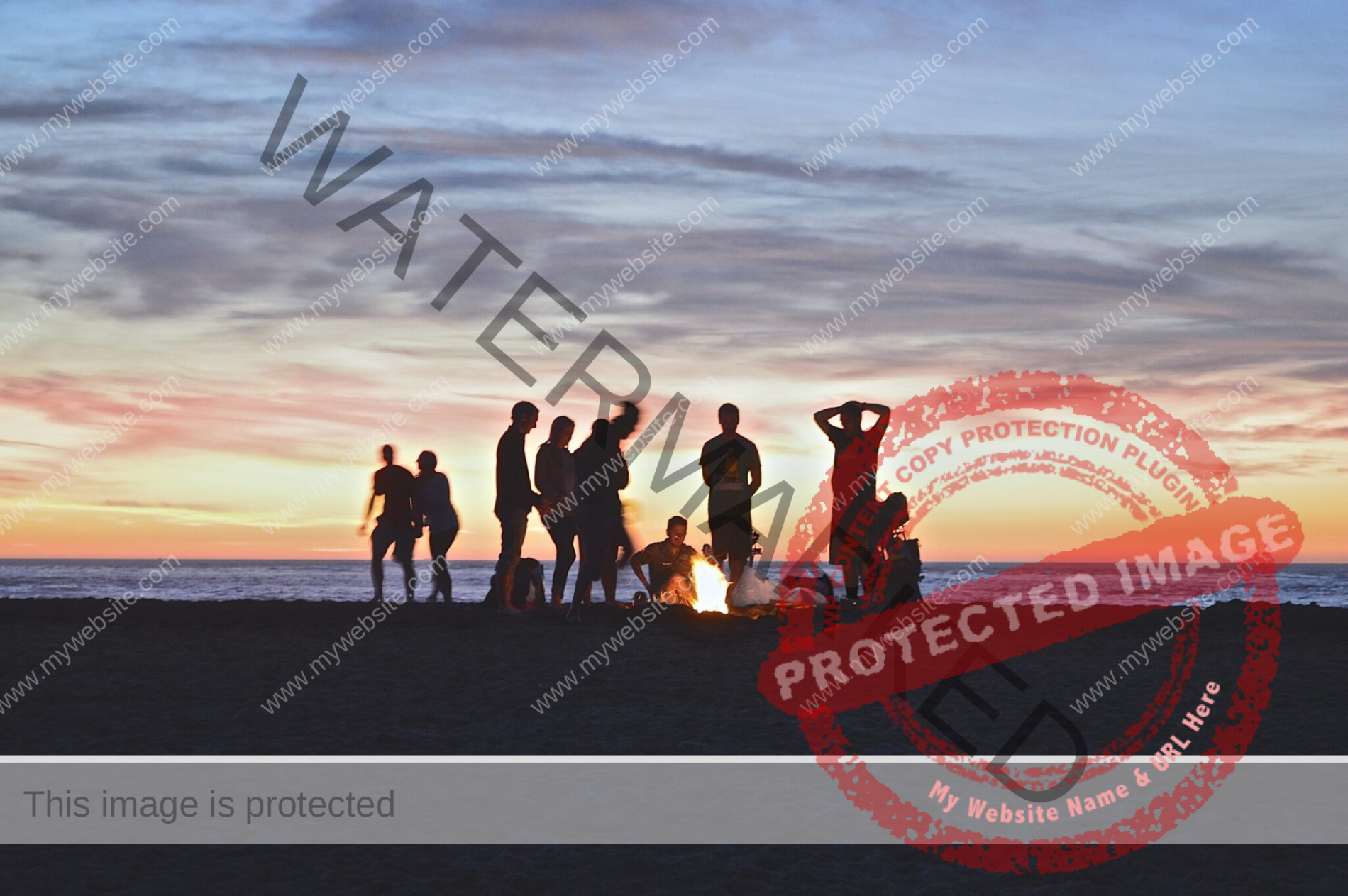 silhouettes of people standing around a campfire at sundown