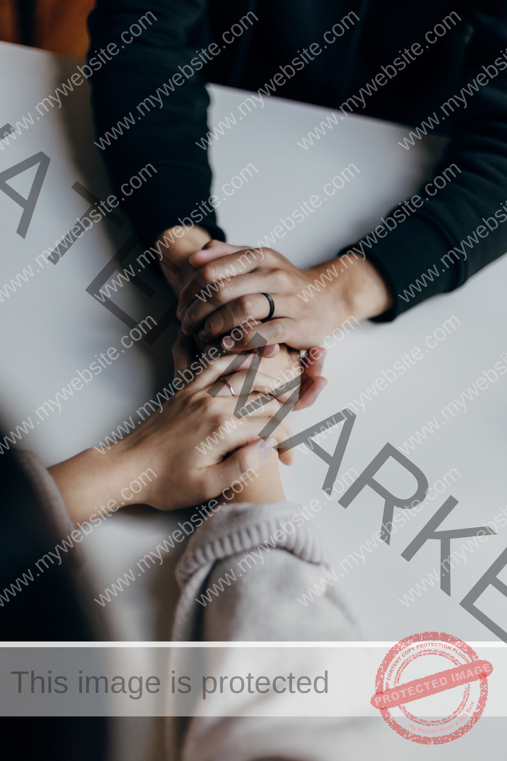 two people hold hands across a table