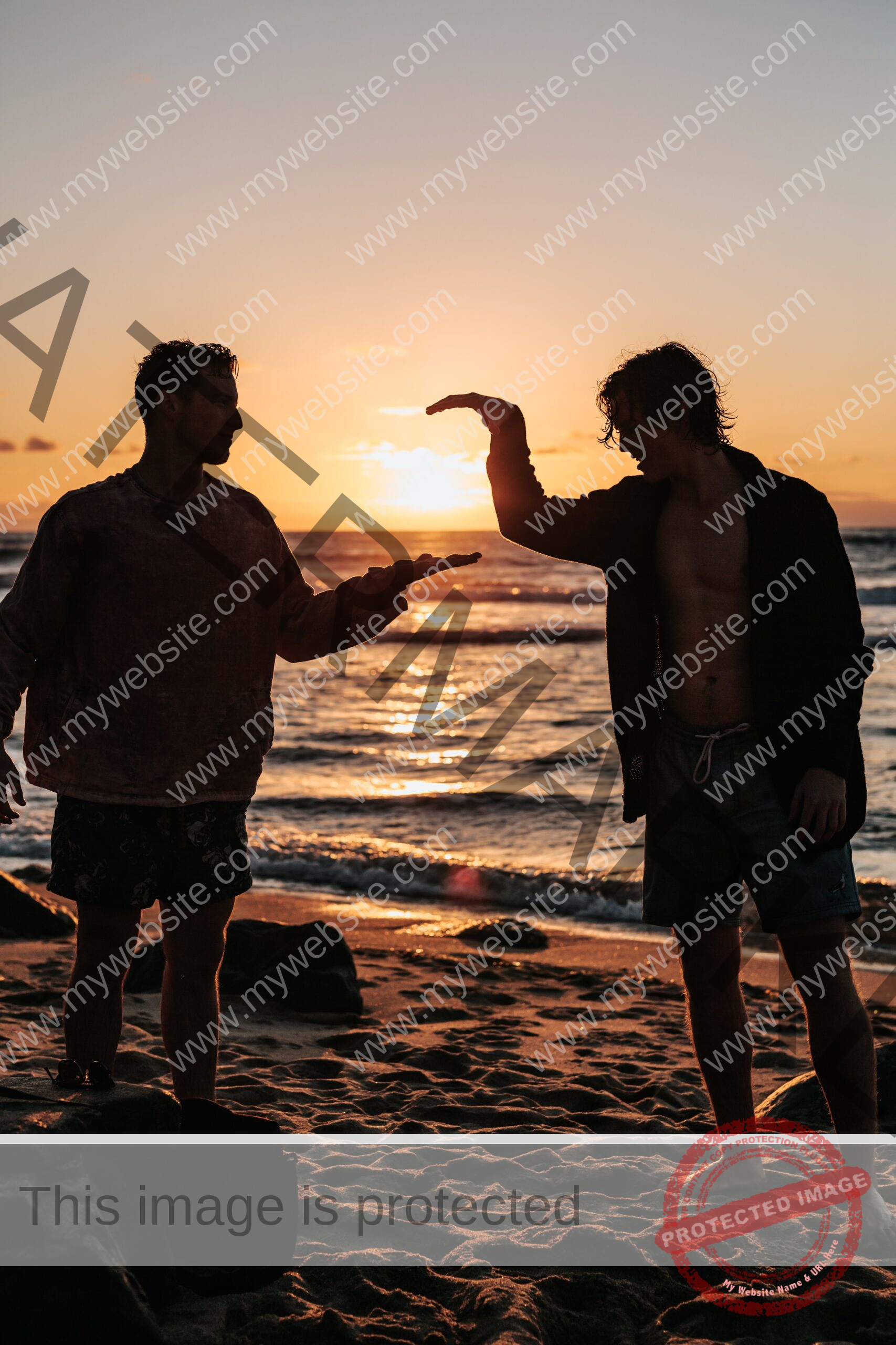 Two guys giving high five on the beach during sunset