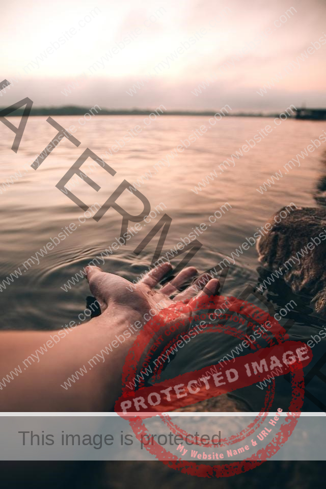 Männliche Hand wird in einen See gehalten