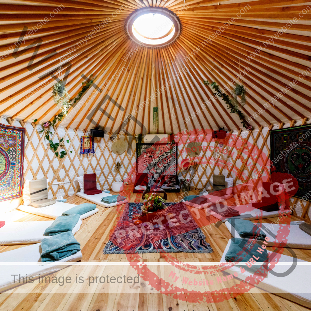 Yurte with mattresses, meditation seats, blankets and sun shining through sealing window