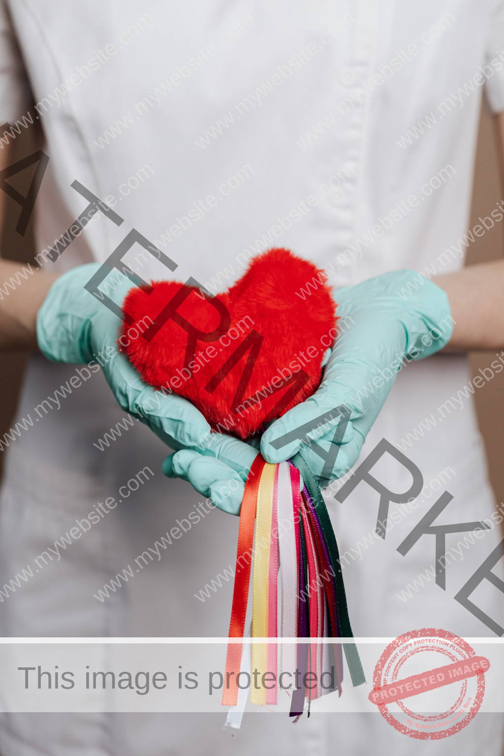 Ärztin hält rotes Plüsch Herz in der Hand und hat hellblaue Gummihandschuhe an