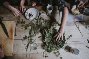 A table full of dried herbs with people working with them