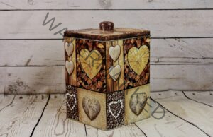a storage tin with hearts on it siting against a wooden background