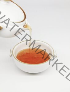 a white teapot pouring tea into a white cup on a white background