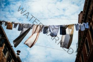 clothes drying on a line with a clear but cloudy blue sky 