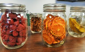 various glass jars filled with dried fruit oranges and raspberries