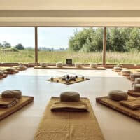 Ceremony room with huge window wall, many mattresses, pillows and blankets