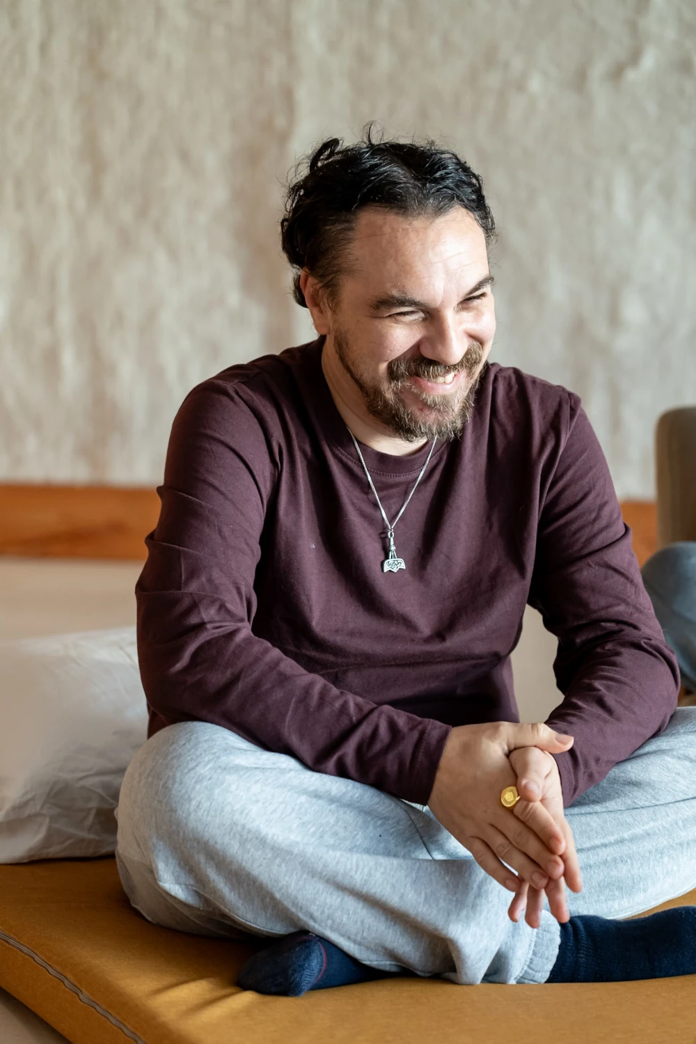 Smiling guy sitting on mattress