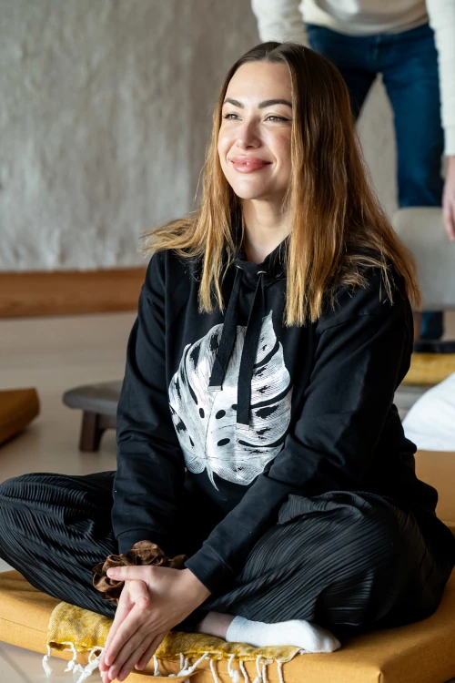 Young woman sitting cross-legged and smiling