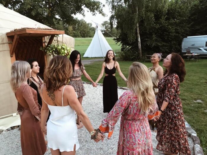 Women circle, holding theire hands and enjoing the moment in peace and calmness