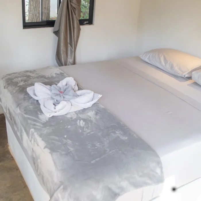 Double bed with white bed sheets in private bungalow