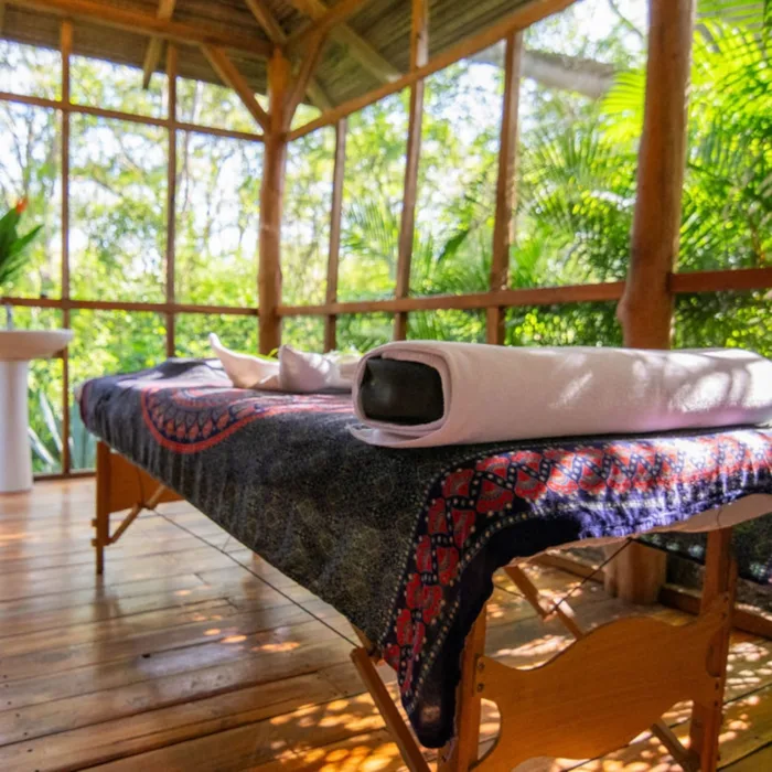 Massage bench with mandala blanket and pillow in an open air room