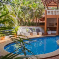 Pool with sun loungers in front of an orange building