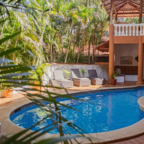 Pool with sun loungers in front of an orange building