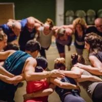 Group of people standing in a circle and holding each other