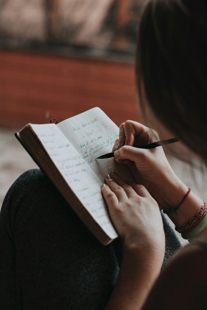 Woman sitting and writing in Journal
